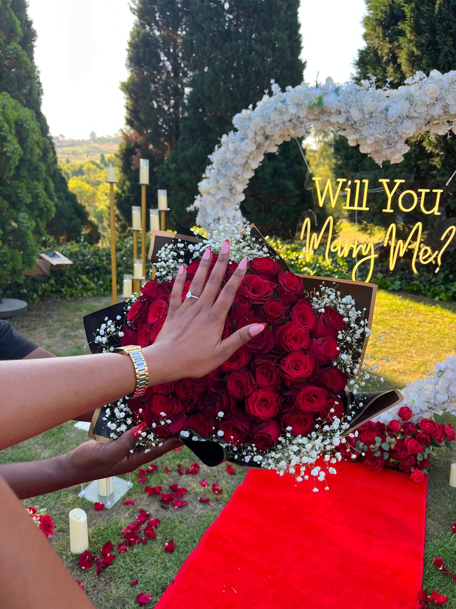 Close-up of Ellen's engagement ring surrounded by red roses